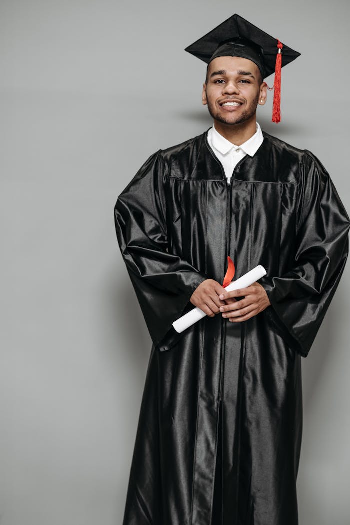 Photo of Man in Black Academic Dress Holding Diploma